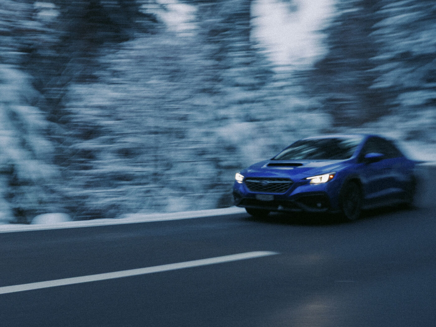 Subaru WRX fahrend im Winterwald